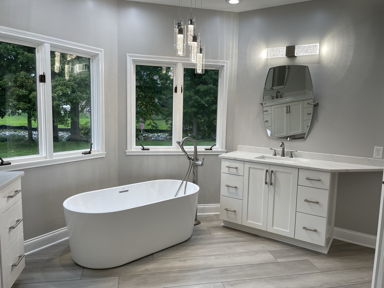A custom bathroom with a marble vanity and freestanding tub by Argent Concepts