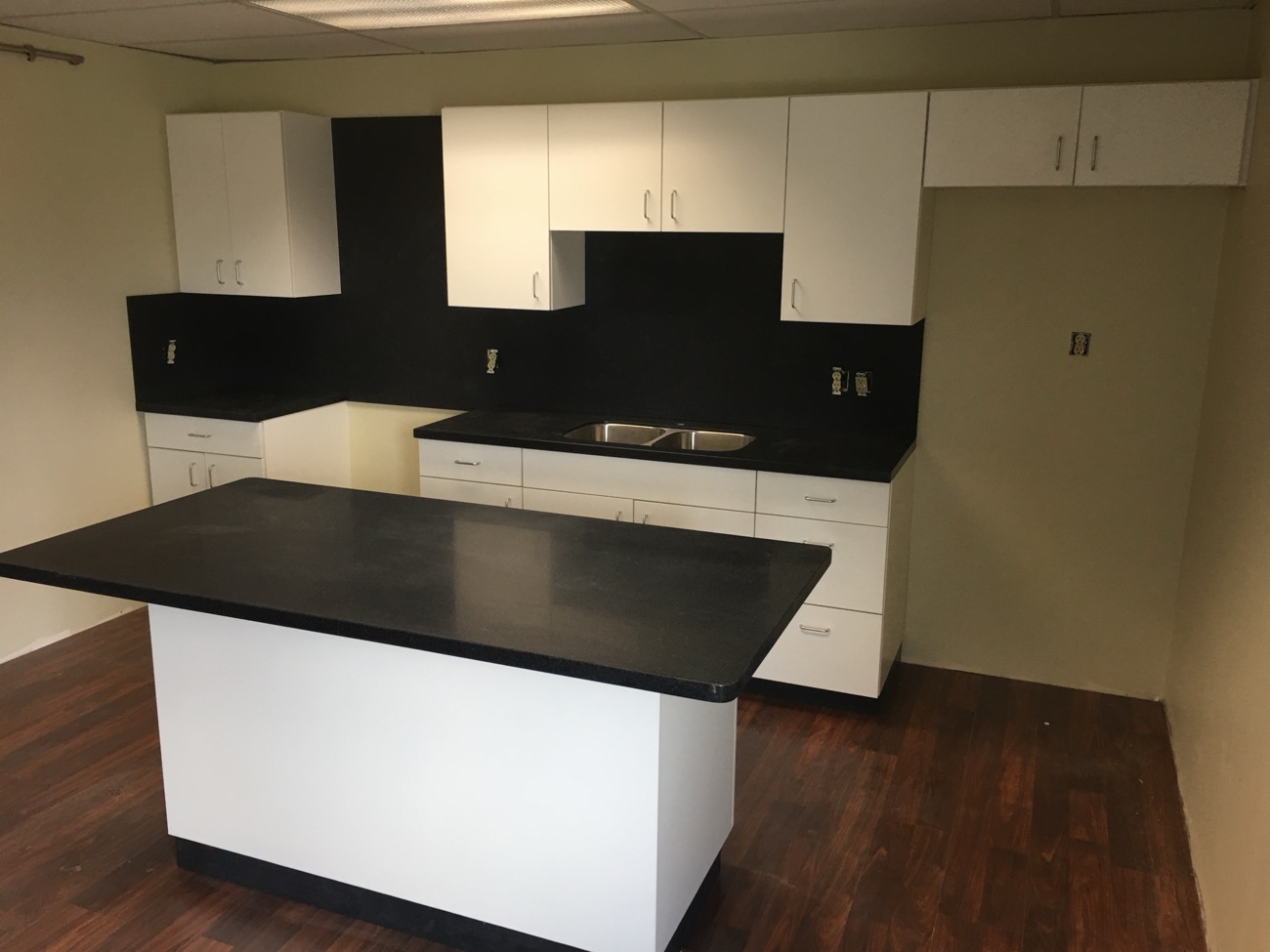 Dark-island kitchen with stone countertops by Argent Concepts